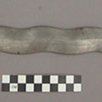 Sword - wavy steel blade, steel hand guard over horn grip, which is +