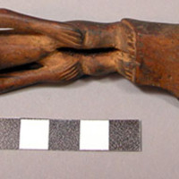 Wooden fork, 4 prongs, handle carved in human effigy: female, hands resting on f