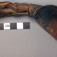 Wooden spoon, handle carved in human effigy: hands resting on flexed knees, no h