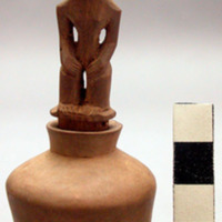 Small wooden bottle or jar with a plugged bottom, carved wooden stopper in form