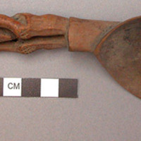 Wooden spoon, handle carved in human effigy: hands resting on flexed knees, carv