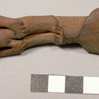 Wooden fork, 4 prongs, handle carved in human effigy: hands resting on flexed kn
