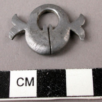 Lead ornament (for necklace?), 2.7 x 2.2 cm.