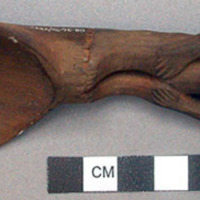 Wooden spoon, handle carved in human effigy: hands resting on flexed knees, turb