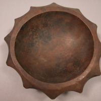 Carved, Carved, dark colored wooden bowl with scalloped edges, pierced for hangi